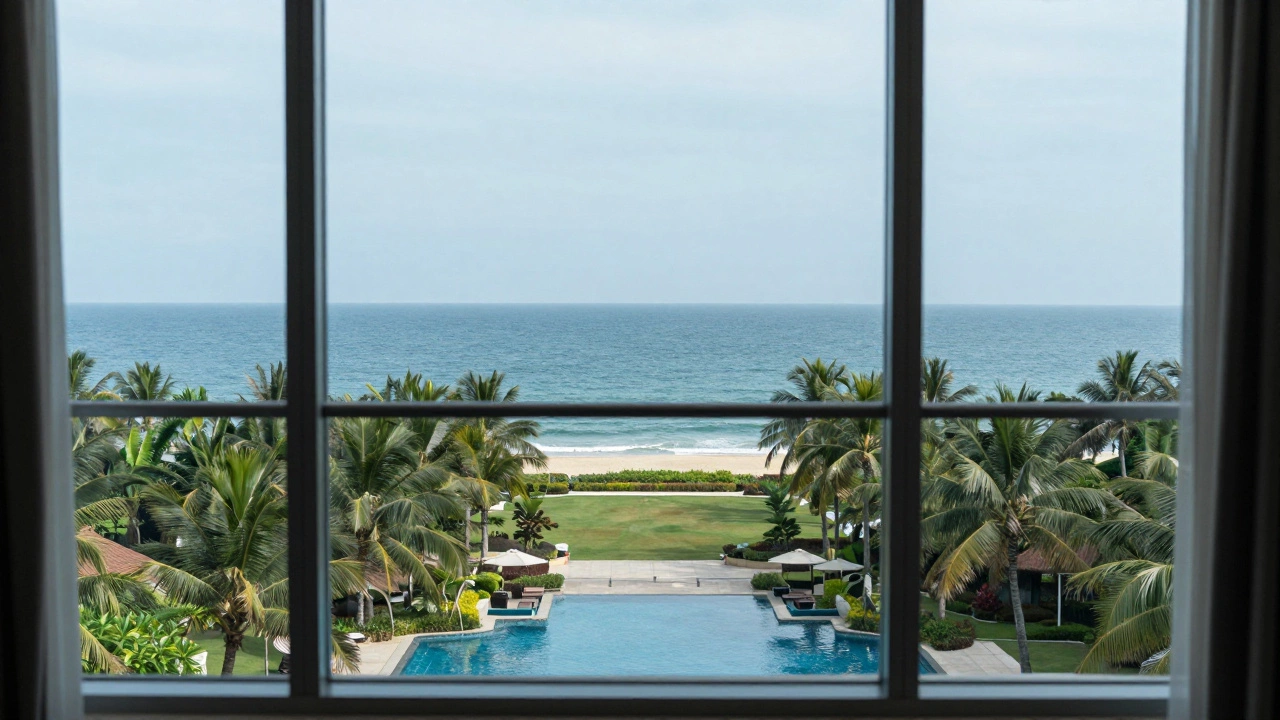 High-rise hotel room interior looking out over a garden and pool towards a distant ocean horizon